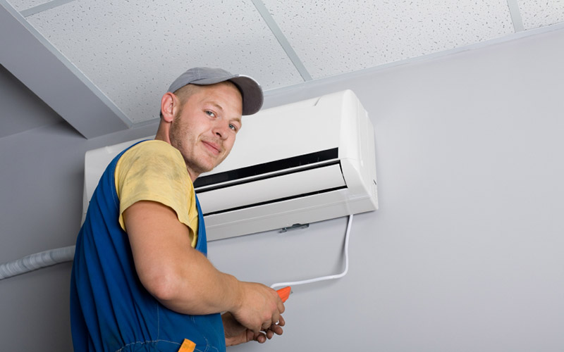 service tech with a ductless, wall mounted  ac unit